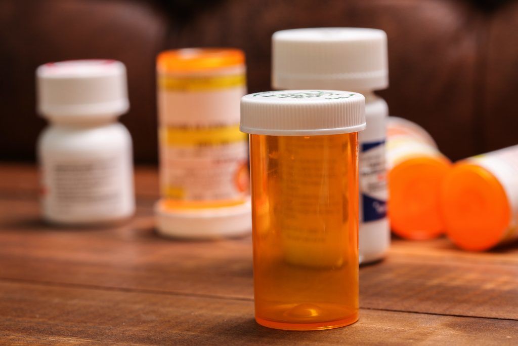 Empty orange medication boxes on table, the dangers of delaying your medication review, e-surgery