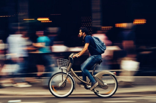 Man on an electrical bike riding through a city | The Real Gains from a Healthy Commute | e-Surgery 