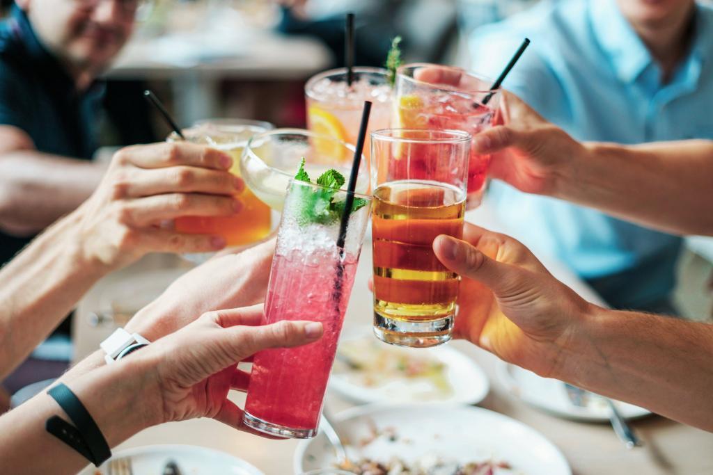 Group of people celebrating with alcoholic beverages. They are all clinking glasses in the centre of the table | The Traditional Office Is Dead: Welcome To A New Era Of 9-5 | e-Surgery 