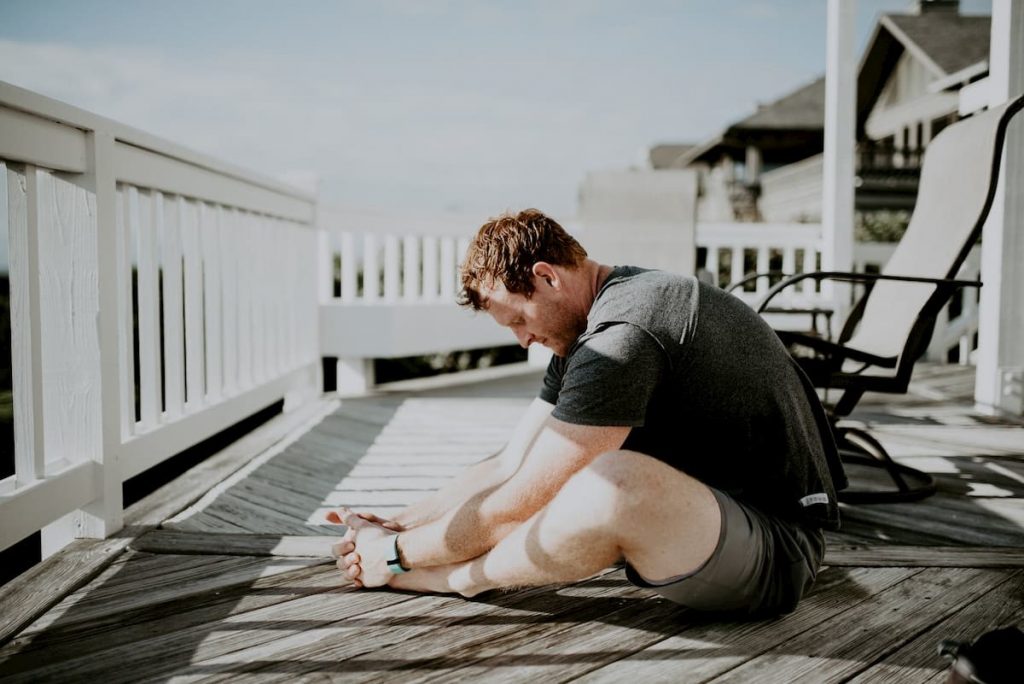 Man doing yoga outside to reduce burnout