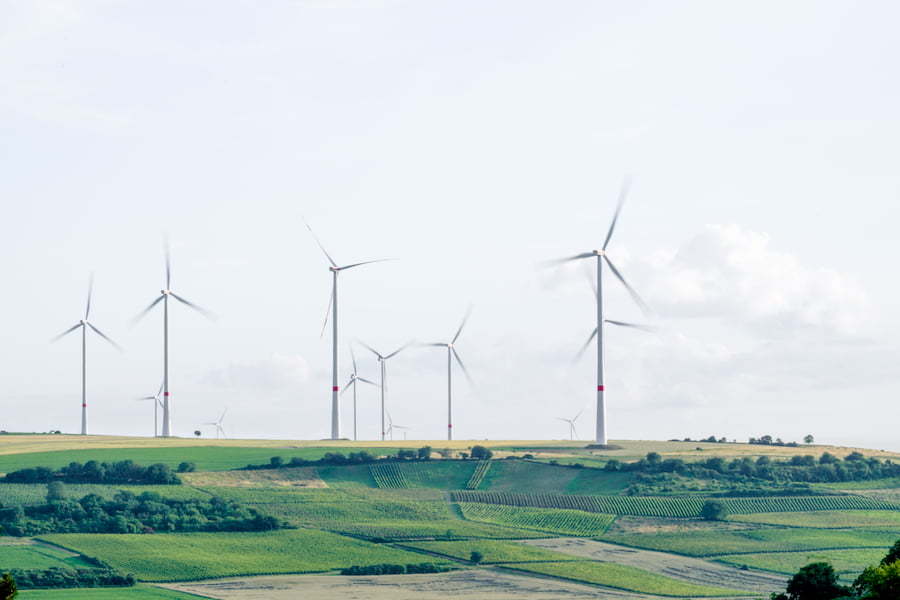 Landscape image of green fields and white windmills against the sky, e-surgery the eco pharmacy