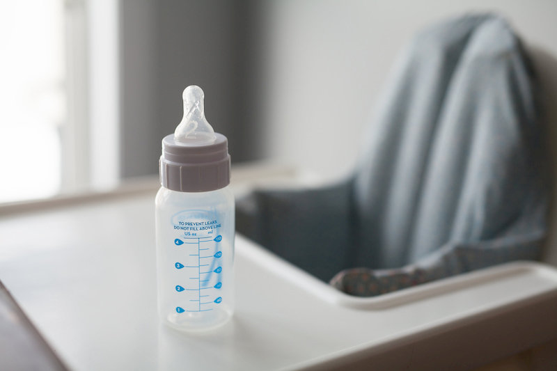 Image of baby bottle on high chair