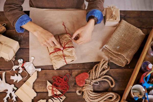 Person wrapping christmas presents in brown paper