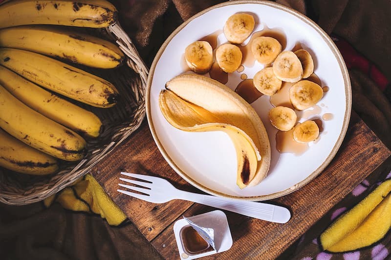 Plate of bananas cut up next to bowl of whole bananas, potassium is a good way to reduce high blood pressure, e-Surgery