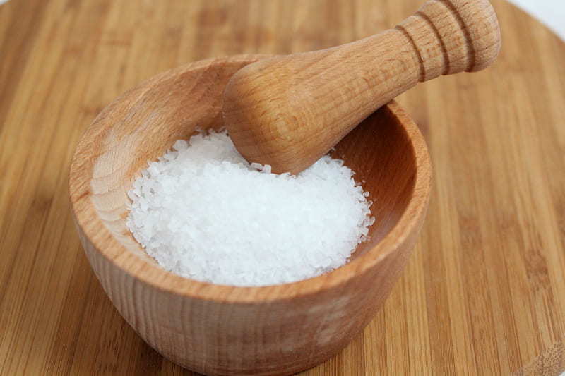 Wooden bowl with salt and grinder on table, reducing salt can help to reduce blood pressure, e-Surgery