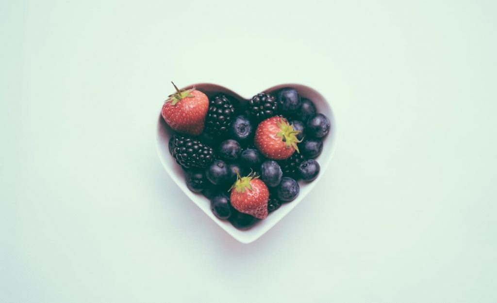 Heart shaped bowl of fruit, is eating vegan healthy | e-surgery