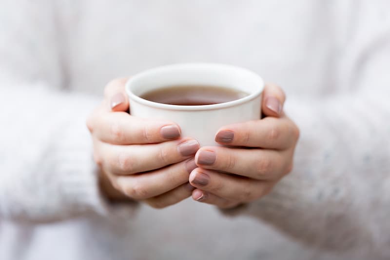 Woman holding mug of herbal tea, chamomile tea can work as hay fever home remedy, e-Surgery