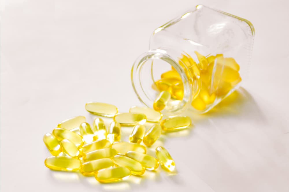 Clear bottle of yellow pills falling out onto white table, are sunblock pills safe? e-Surgery