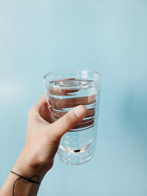 Hand holding glass of water