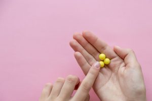 Hand holding yellow hay fever tablets