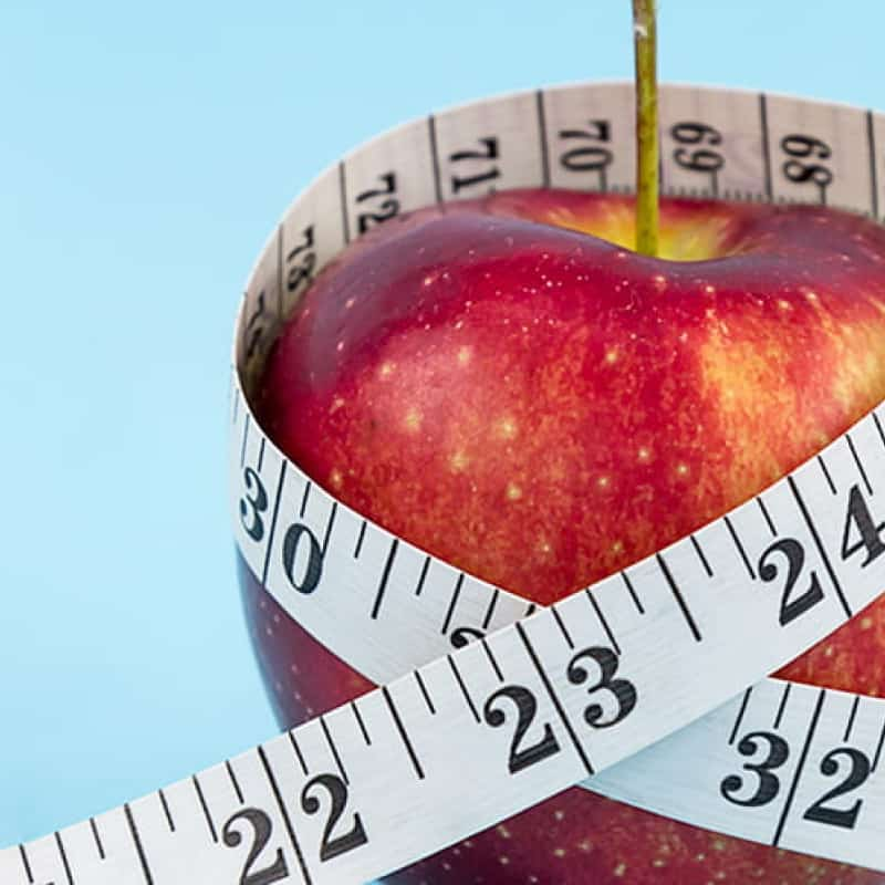 Red apple with tape measure wrapped around it on blue background, orlistat and xenical do they work for weight loss, e-Surgery