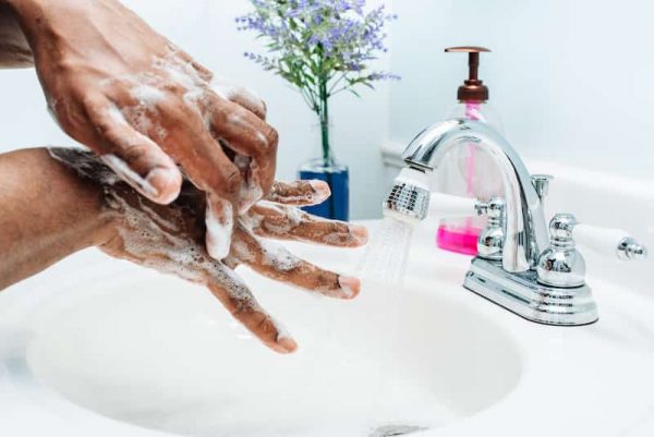 Person washing hands with soap and water