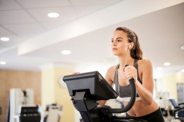 Woman working out on treadmill, ways to stop your period safely, e-Surgery