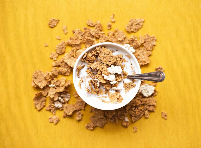 Bowl of healthy cereal with milk on yellow table, vitamin B12 is found in fortified vegan cereal, e-Surgery