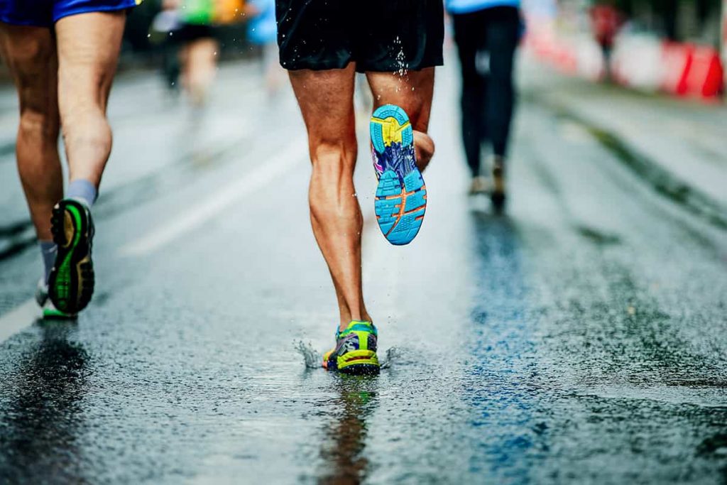 Low profile of men running forwards from thighs down on wet pavement | What Is Seasonal Affective Disorder And How Can You Treat It? | e-Surgery 