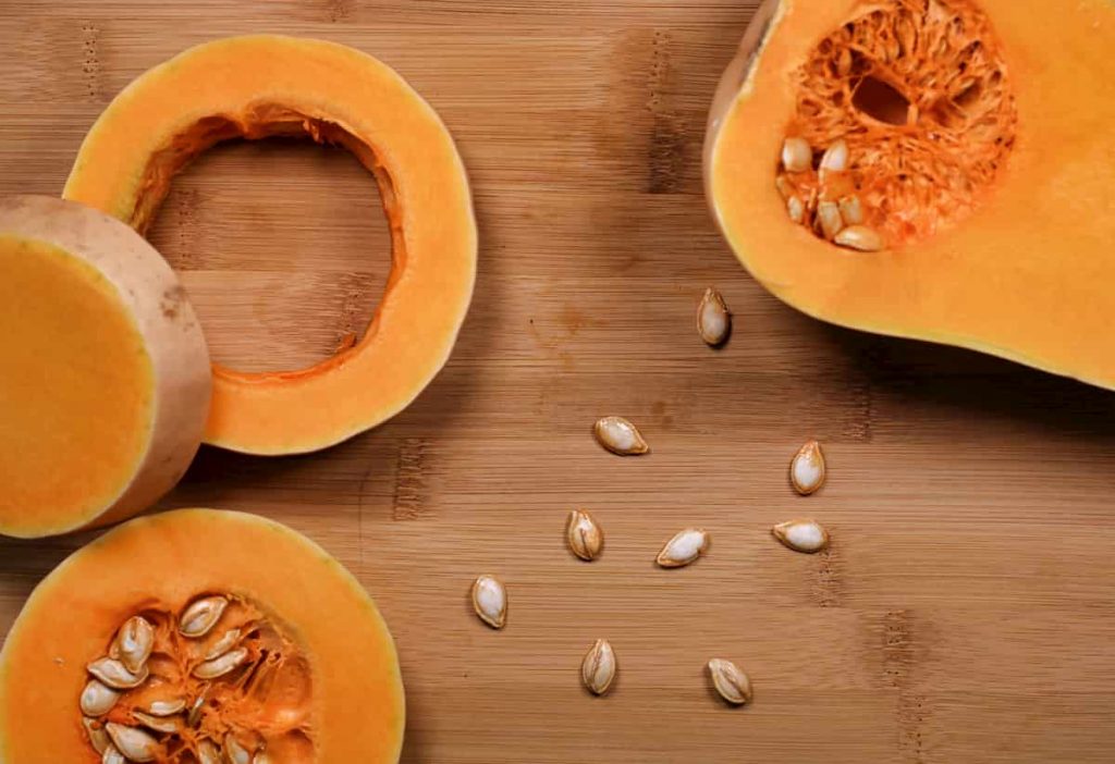 Butternut squash cut open on wooden board