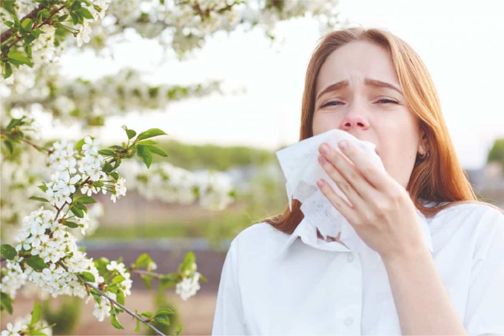 Woman sneezing due to hay fever