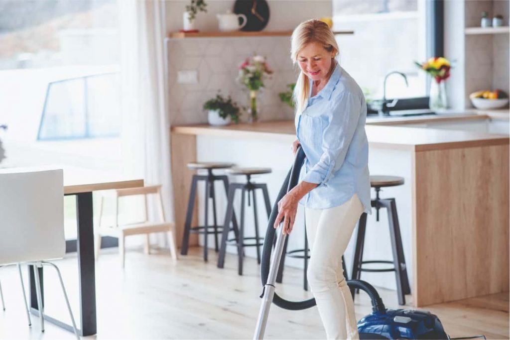 Woman hoovering home to reduce hay fever caused by dust