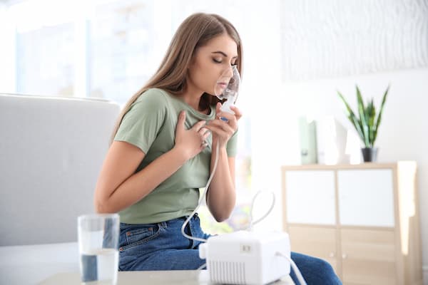 Woman using nebuliser for asthma