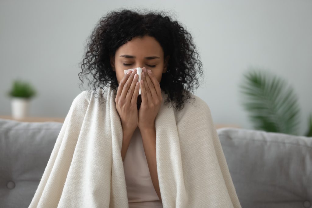 Woman blowing nose fighting her winter illness