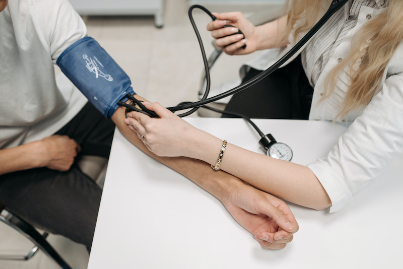 Doctor using high blood pressure pump on patient