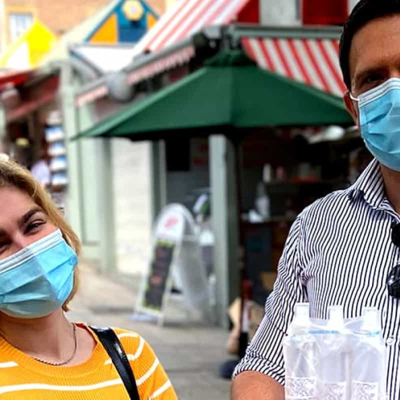 e-Surgery CEO's smiling in Norwich Market handing out free hand sanitiser