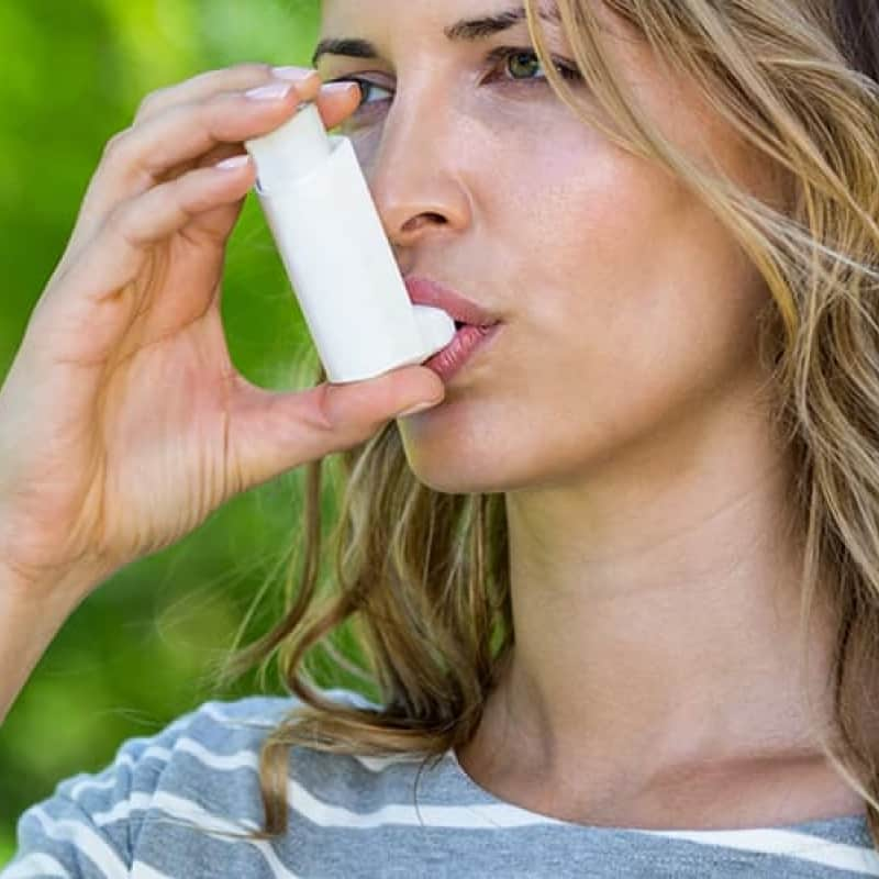 Woman using white inhaler, asthma review, e-Surgery