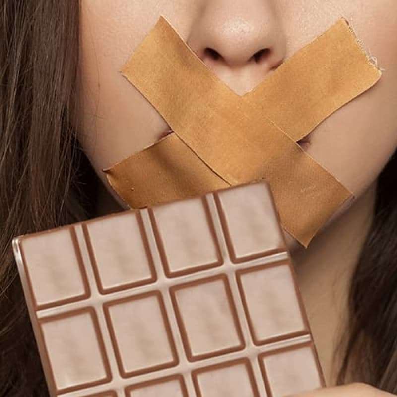 Woman with tape over mouth holding bar of chocolate, this is why chocolate can actually be good for you! e-Surgery