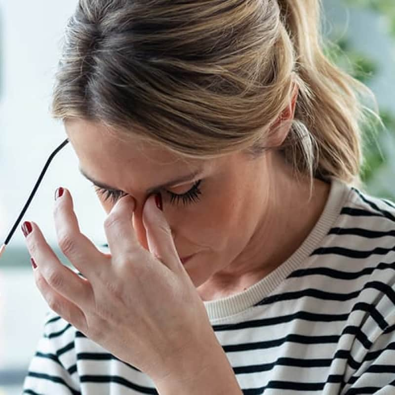 Woman holding head in pain, different types of migraine