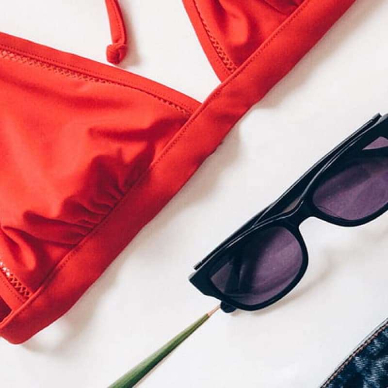 Holiday essentials, sunglasses and a red bikini, period delay from e-Surgery