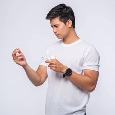 young man inspecting his Azithromycin or Doxycycline antibitotics | e-surgery